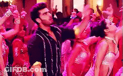 A Man And A Woman Are Dancing In Front Of A Crowd Of People . GIF