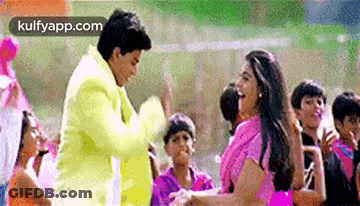 A Man And A Woman Are Dancing In Front Of A Crowd . GIF
