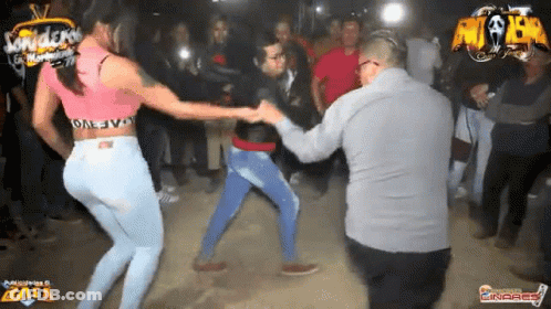 A Man And A Woman Are Dancing In Front Of A Crowd With A Sign That Says Andres GIF