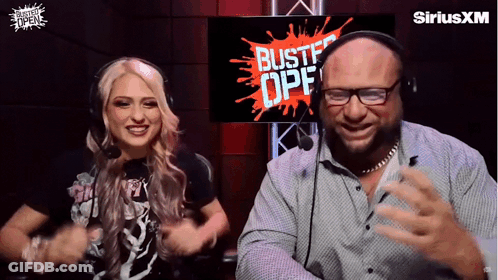 A Man And A Woman Are Dancing In Front Of A Screen That Says Bustf Opf GIF