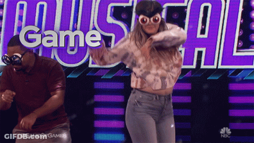 A Man And A Woman Are Dancing In Front Of A Screen That Says Game Of Games GIF