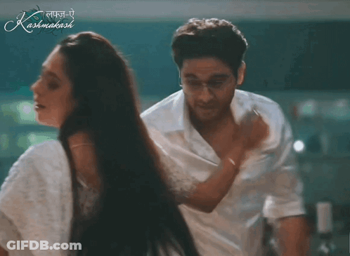 A Man And A Woman Are Dancing In Front Of A Sign That Says Kashmakash GIF