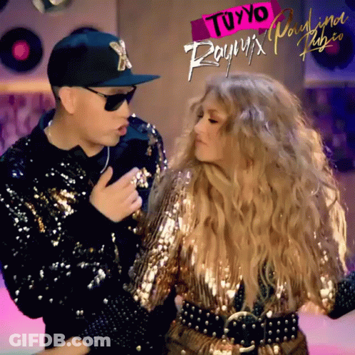 A Man And A Woman Are Dancing In Front Of A Sign That Says " Tuyyo " On It GIF