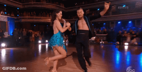 A Man And A Woman Are Dancing On A Dance Floor GIF
