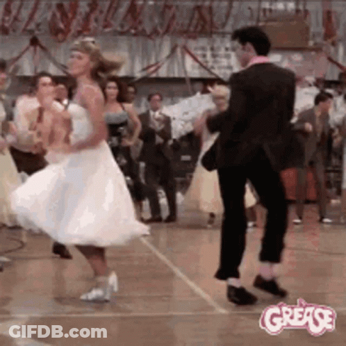 A Man And A Woman Are Dancing On A Dance Floor In A Room . GIF