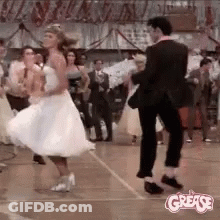 A Man And A Woman Are Dancing On A Dance Floor In A Room . GIF