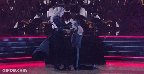 A Man And A Woman Are Dancing On A Dance Floor GIF