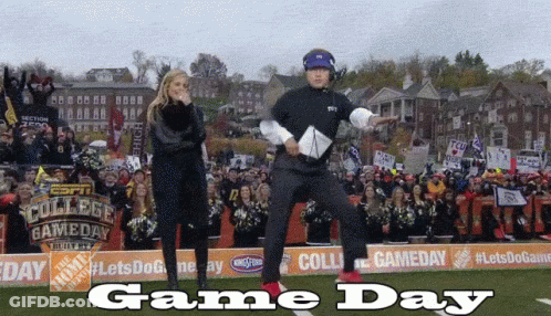 A Man And A Woman Are Dancing On A Field With The Words Game Day On The Bottom GIF