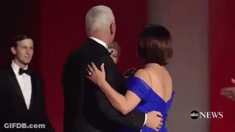 A Man And A Woman Are Dancing On A Red Carpet . GIF