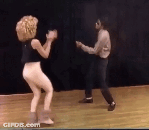 A Man And A Woman Are Dancing On A Stage . GIF