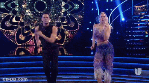 A Man And A Woman Are Dancing On A Stage GIF