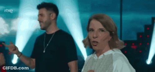 A Man And A Woman Are Dancing On A Stage With The Letters Rtve Behind Them GIF