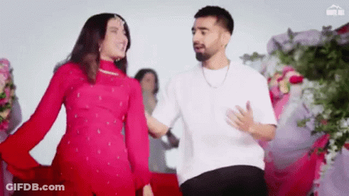 A Man And A Woman Are Dancing Together In A Room . GIF