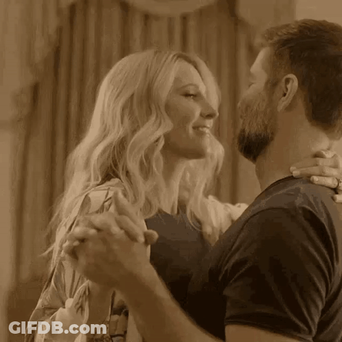 A Man And A Woman Are Dancing Together In A Room In A Sepia Tone . GIF