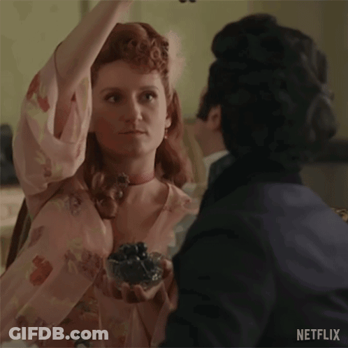 A Man And A Woman Are Dancing Together In A Room . The Woman Is Wearing A Pink Dress And A Choker . GIF