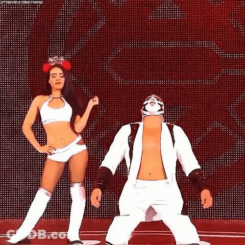 A Man And A Woman Are Dancing Together On A Stage . GIF