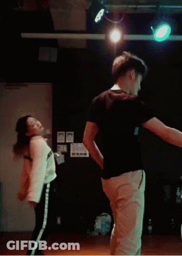 A Man And A Woman Are Doing A Trick In Front Of A Sign That Says Play The Game GIF