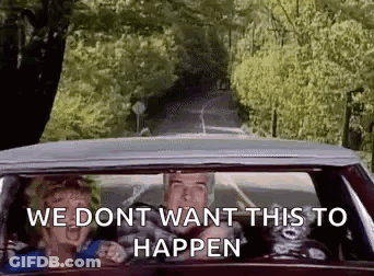 A Man And A Woman Are Driving A Car Down A Country Road . GIF