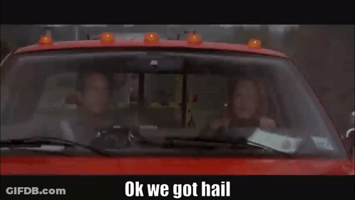 A Man And A Woman Are Driving A Red Truck With The Words `` Ok We Got Hail '' Written On The Bottom . GIF