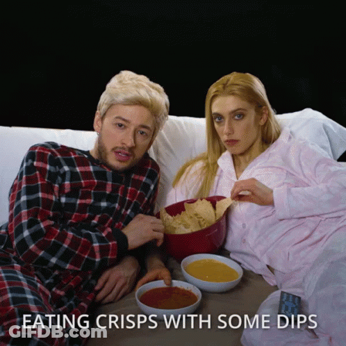 A Man And A Woman Are Eating Crisps With Dips GIF