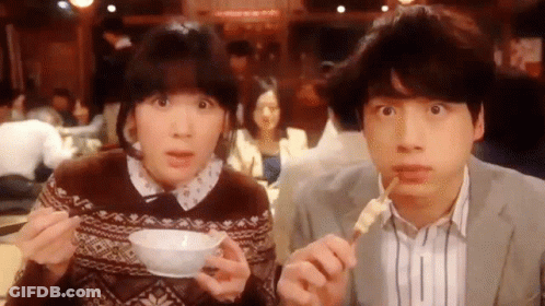 A Man And A Woman Are Eating Food With Chopsticks And A Bowl Of Soup . GIF