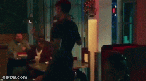 A Man And A Woman Are Fighting In A Restaurant . GIF