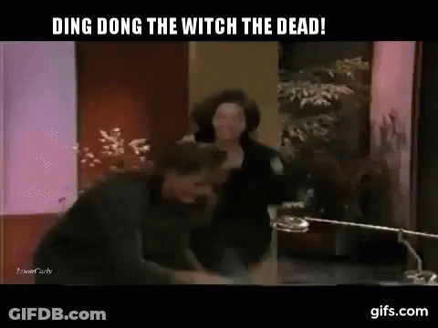 A Man And A Woman Are Fighting In A Room With The Words Ding Dong The Witch The Dead GIF