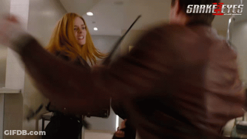 A Man And A Woman Are Fighting In A Scene From Snake Eyes GIF