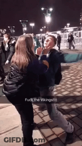 A Man And A Woman Are Fighting With The Words Fuck The Vikings On The Bottom Right GIF