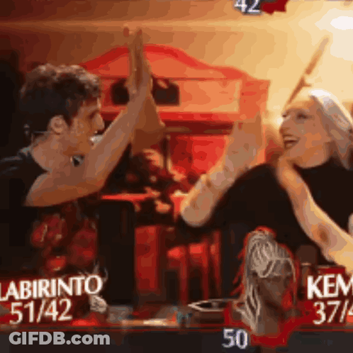 A Man And A Woman Are Giving Each Other A High Five In Front Of A Sign That Says Labirinto 51/42 GIF
