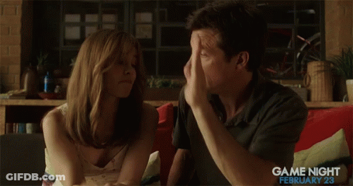A Man And A Woman Are Giving Each Other A High Five While Sitting On A Couch .. GIF