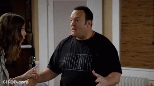 A Man And A Woman Are Having A Conversation In A Living Room . GIF