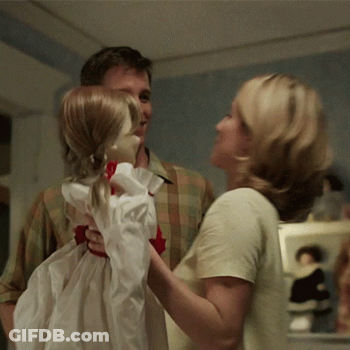 A Man And A Woman Are Holding A Little Girl Doll GIF