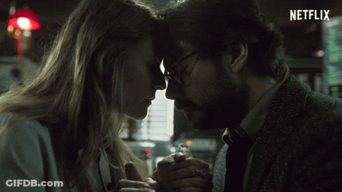 A Man And A Woman Are Holding Hands With A Netflix Logo In The Background GIF