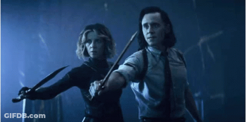 A Man And A Woman Are Holding Knives In A Dark Room . GIF