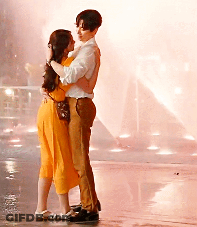 A Man And A Woman Are Hugging And Kissing On A Wet Floor GIF