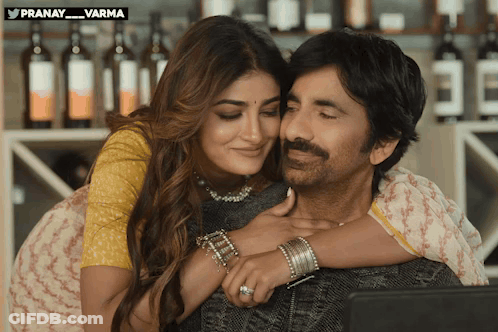 A Man And A Woman Are Hugging And Looking At A Laptop With A Watermark That Says Pranay Varma GIF