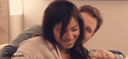 A Man And A Woman Are Hugging And Smiling GIF