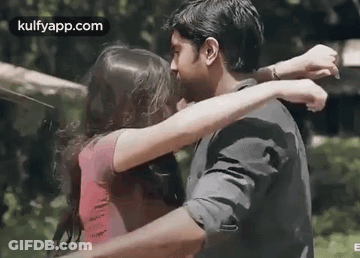 A Man And A Woman Are Hugging Each Other And Kissing . GIF