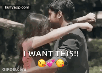 A Man And A Woman Are Hugging Each Other And Kissing . GIF
