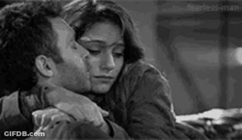 A Man And A Woman Are Hugging Each Other And Kissing . GIF