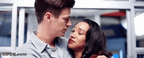A Man And A Woman Are Hugging Each Other And Looking At Each Other In A Room . GIF