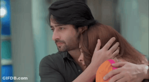 A Man And A Woman Are Hugging Each Other And The Man Is Holding The Woman 'S Head . GIF