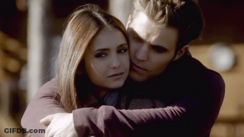 A Man And A Woman Are Hugging Each Other And The Man Is Kissing The Woman On The Forehead GIF
