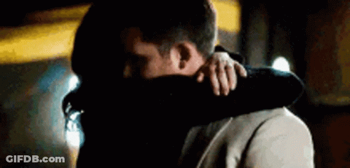 A Man And A Woman Are Hugging Each Other . GIF