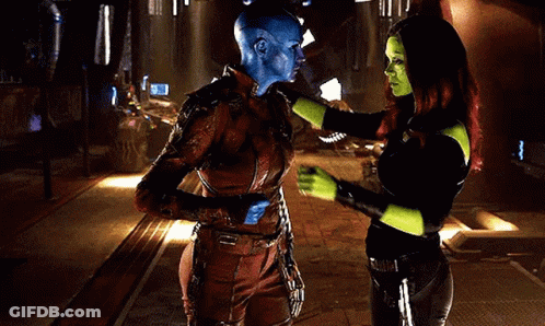 A Man And A Woman Are Hugging Each Other In A Room . The Man Is Wearing A Blue Mask . GIF