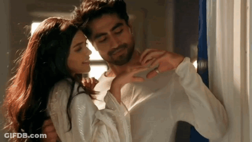 A Man And A Woman Are Hugging Each Other In A Room . The Woman Is Wearing A Wedding Ring . GIF