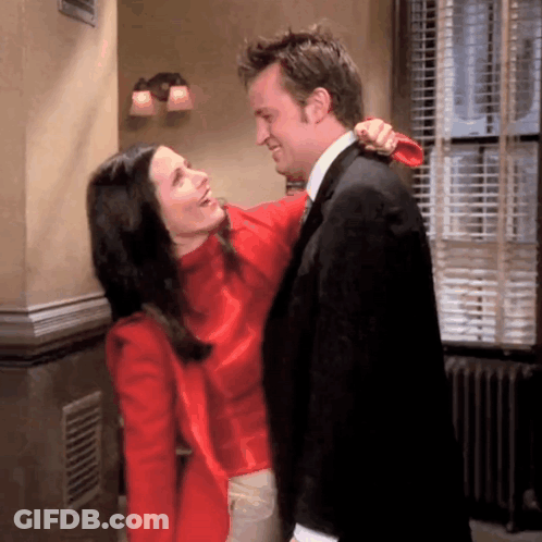 A Man And A Woman Are Hugging Each Other In A Room GIF