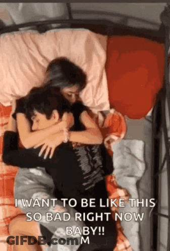 A Man And A Woman Are Hugging Each Other On A Bed With The Words " I Want To Be Like This So Bad Right Now Baby " GIF