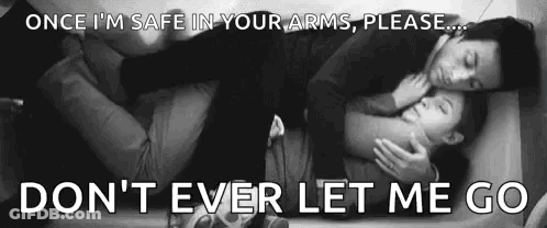 A Man And A Woman Are Hugging Each Other While Laying On A Bed . GIF